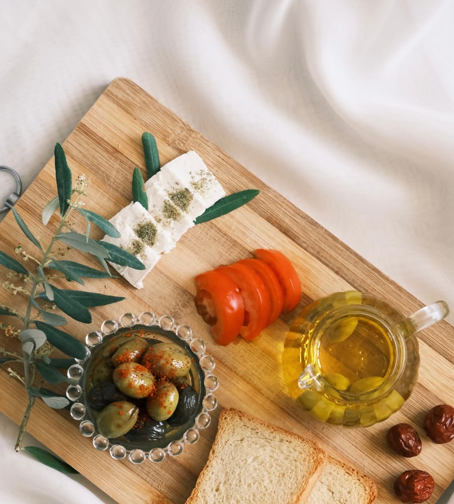 Spread of Mediterranean diet foods including olive oil, vegetables, and whole grains.