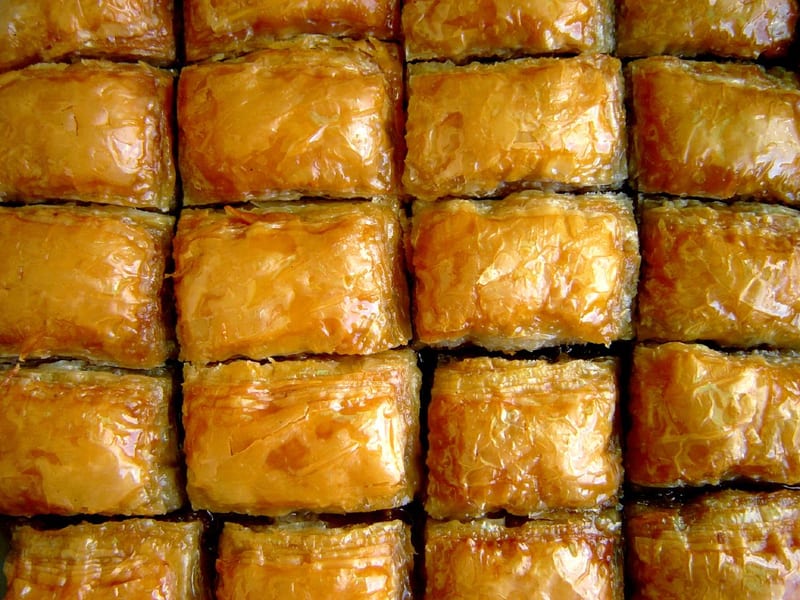 A full tray of glossy, diamond-cut baklava soaked in honey syrup.