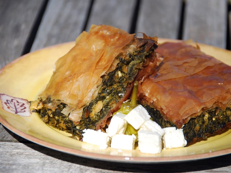 Baked spanakopita slices with flaky golden phyllo layers, served with cubes of feta.